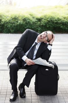 Portrait of Desperate businessman with newspaper in his hands 