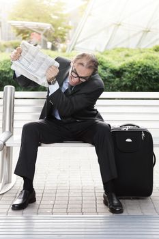 Portrait of Angry businessman with newspaper in his hands 