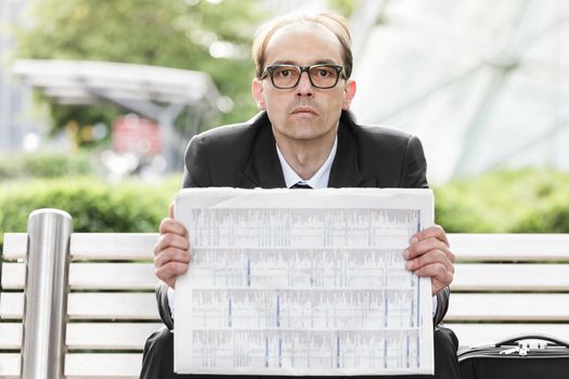 Portrait of Sad businessman with newspaper in his hands 