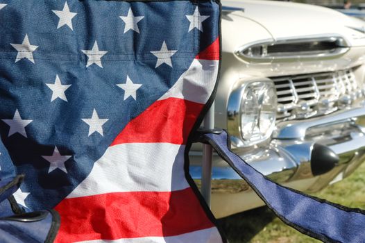 stars and stripes with a classic americana vehicle in the background