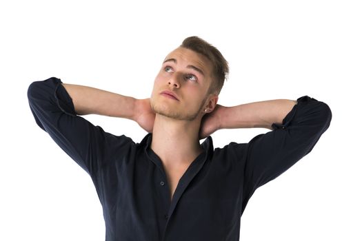 Cool confident blond young man with blue shirt, hands behind head, isolated on white