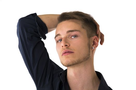 Cool confident blond young man with blue shirt, hand above head, isolated on white