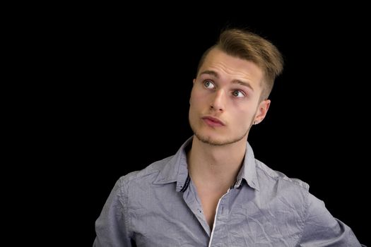 Attractive blond, blue eyed young man with serious expression, looking up, isolated