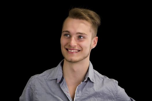 Attractive blond, blue eyed young man smiling and looking away, isolated
