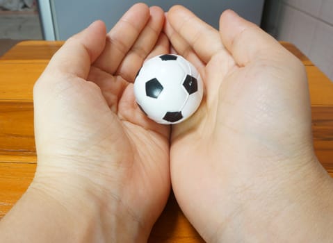 Small white ball In the two hands of the woman.                               