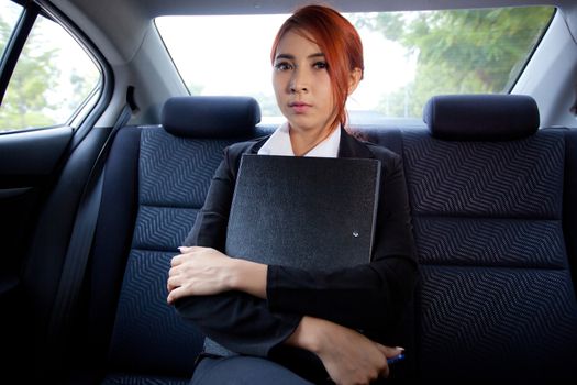 Beautiful young business asian with document in a car