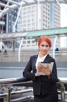 Young business asian woman with tablet at modern city