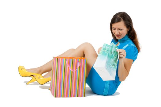 Young woman with packages sitting on the floor