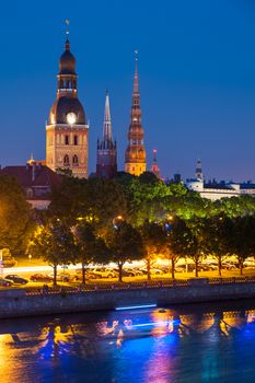 Towers of Riga seen across the river Daugava after the sunset. Three church towers in the picture are the Riga Dome cathedral,  St. Saviour's Church and St. Peter's church. On the right is Building of Academy of Sciences