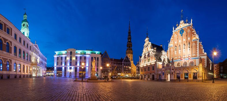 Famous House of Blackheads on the Town Square in Riga with a Church of St. Peter in the back. Latvia, after sunset.  House of Blackheads, destroyed during 2 World War, was reconstructed in the 1999. Panorama