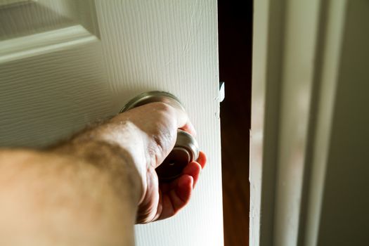 hand on a door knob getting ready to open into the unknown