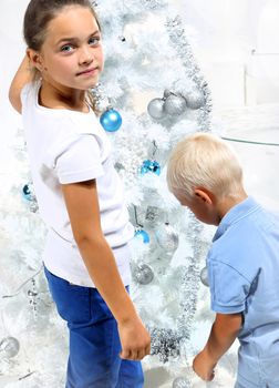 Brother and sister decorate the Christmas tree