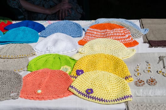 crocheted colorful baby summer hat lying on the stall fair