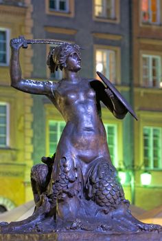 The most famous Warsaw Mermaid - a 19th century sculpture by Konstanty Hegel - in the centre of the Old Town Market Square, Warsaw, Poland. A half-fish, half-woman with a sword and a shield in her hands is a symbol of the capital city.