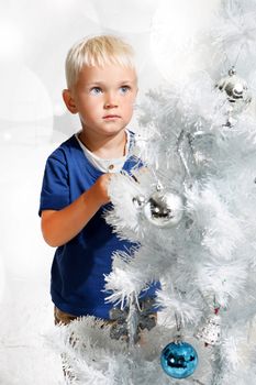 Boy dresses up Christmas tree
