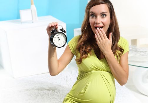 Pregnant woman with an alarm clock