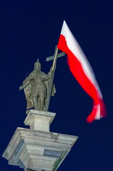 King Sigismund’s Column stands in the centre of Castle Square, Warsaw, Poland. It is the oldest secular monument in Warsaw (1643).
The King holds a cross with a white-red flag and a sword in his hands.