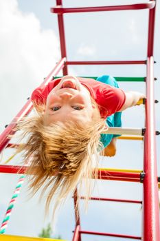 Little girl having fun playing on monkey bars