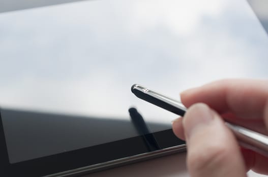 Close-up of woman working with stylus on digital tablet pc 