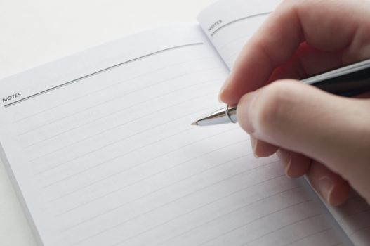 Close up woman's hand taking note