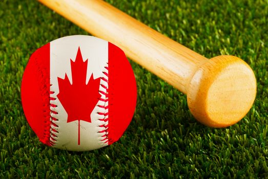 Baseball with Canada flag and bat over a background of green grass