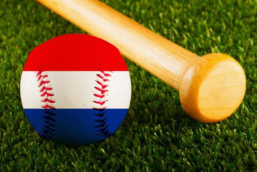 Baseball with Netherlands flag and bat over a background of green grass