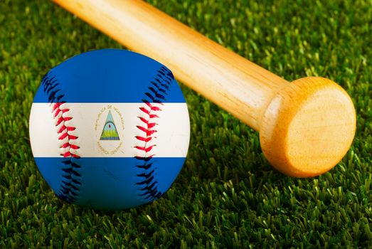 Baseball with Nicaragua flag and bat over a background of green grass