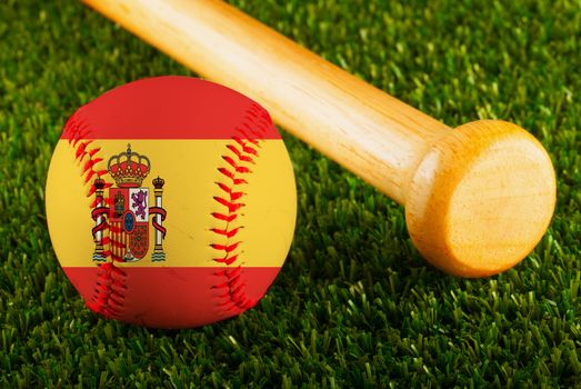 Baseball with Spain flag and bat over a background of green grass
