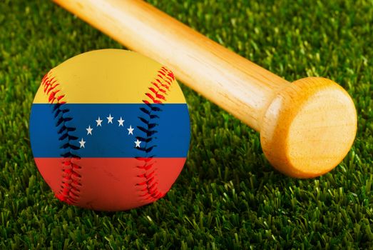 Baseball with Venezuela flag and bat over a background of green grass