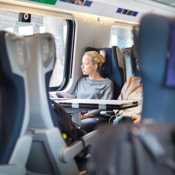 Blonde casual caucasian lady traveling by train.