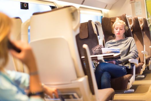 Blonde casual caucasian lady traveling by train.