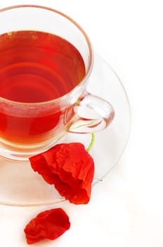 Poppy in glass cup on white table 