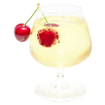 Misted wineglass full of cold white wine with dew drops and isolated ripe red cherry berry pair