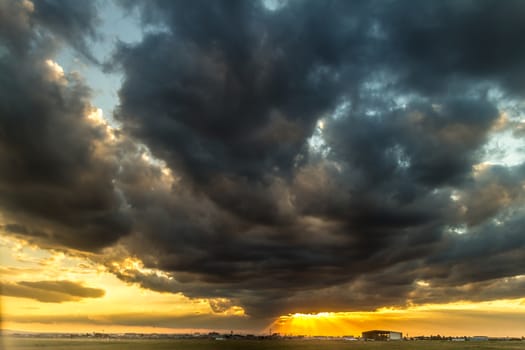 The last rays of the sunset breaking through the stormy clouds over the sky