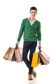 Young Asian man shopping and holding bags, full length portrait isolated on white background.