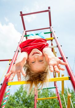 Little girl having fun playing on monkey bars