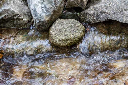 Stones with rapid water stream flowing between