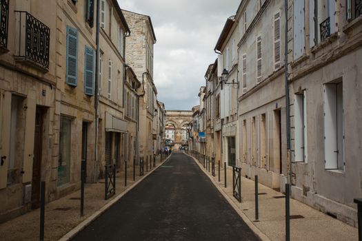 Typical street in Saintes with ist Germanic roman arch at the bottom, Charente,France