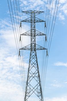 High voltage transmission tower in blue sky background