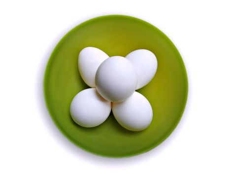 Top view of chicken eggs in a green bowl isolated on a white background.