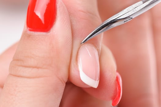 beauty salon, manicure applying, cutting the cuticle with scissors