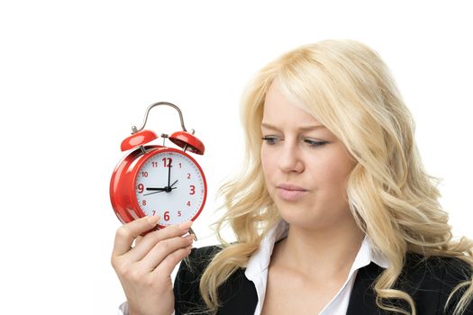 Laughing blond woman unhappy with red alarm clock