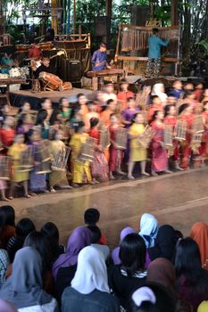 bandung, indonesia-june 16, 2014: kids playing angklung at saung angklung udjo. angklung is traditional musical heritage made from bamboo and worldwide recognize originally from indonesia.