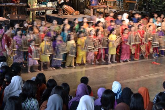 bandung, indonesia-june 16, 2014: kids playing angklung at saung angklung udjo. angklung is traditional musical heritage made from bamboo and worldwide recognize originally from indonesia.