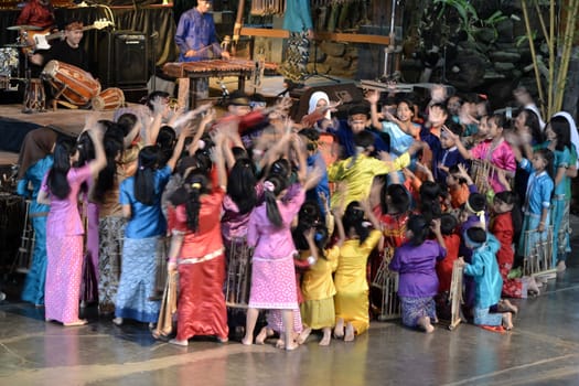 bandung, indonesia-june 16, 2014: kids playing angklung at saung angklung udjo. angklung is traditional musical heritage made from bamboo and worldwide recognize originally from indonesia.