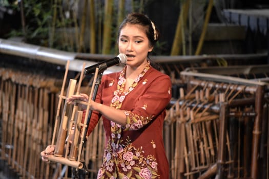 bandung, indonesia-june 16, 2014: beautiful lady as master of ceremony in saung angklung udjo choir.
