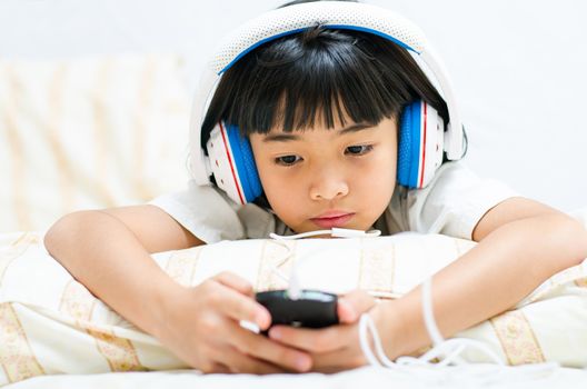 Girl listens attentively to the music by phone.