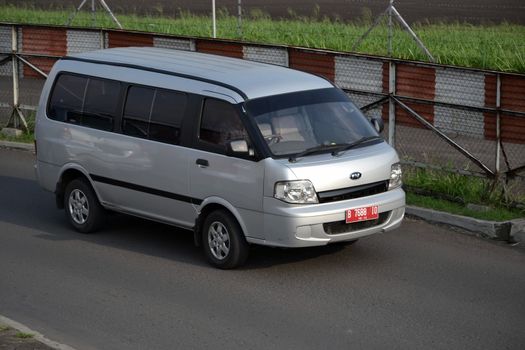 bandung, indonesia-june 16, 2014: silver colored KIA travello cruising on the road.