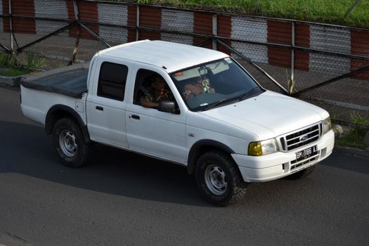 bandung, indonesia-june 16, 2014: white colored ford everest cruising on the road.