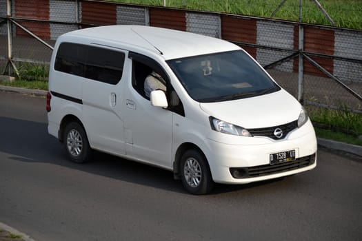 bandung, indonesia-june 16, 2014: white colored nissan evalia cruising on the road.